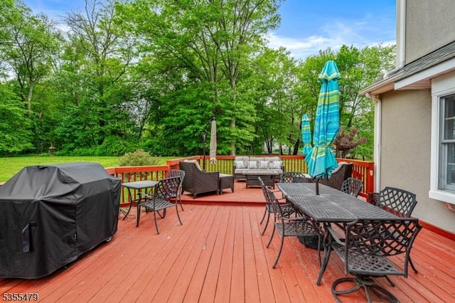 wooden deck with outdoor lounge area, outdoor dining area, a grill, and view of wooded area