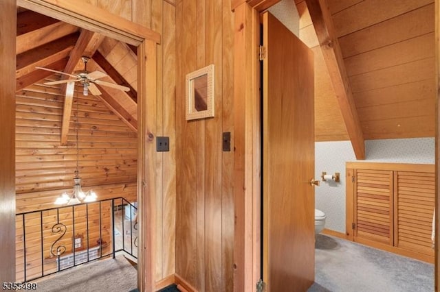 hallway with carpet floors, wooden ceiling, and wood walls