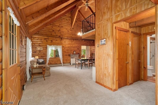 living area featuring ceiling fan, beamed ceiling, high vaulted ceiling, and carpet flooring