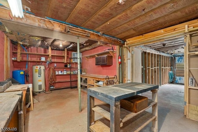 unfinished basement with water heater, a workshop area, and a water pressure tank