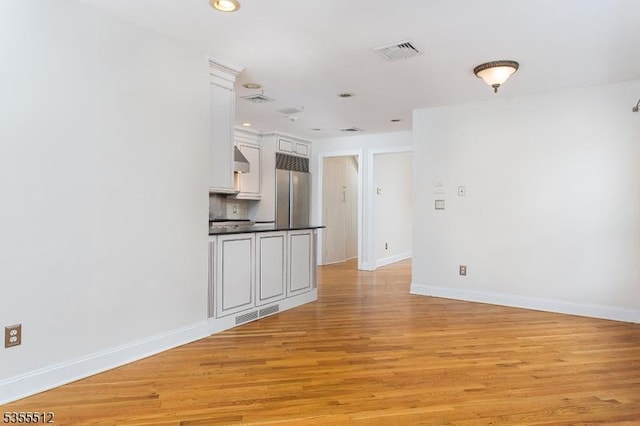 unfurnished room with light wood finished floors, baseboards, and recessed lighting