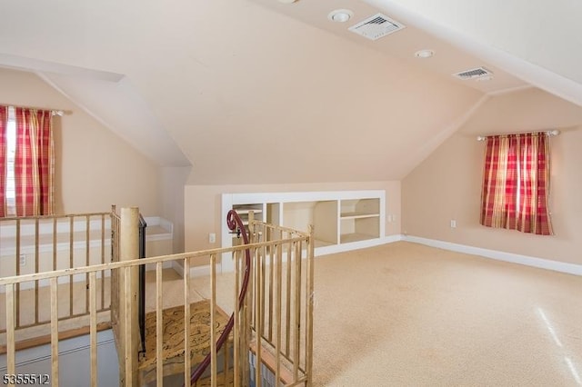 additional living space featuring vaulted ceiling, carpet floors, and baseboards