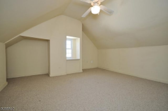 additional living space featuring carpet, lofted ceiling, and a ceiling fan