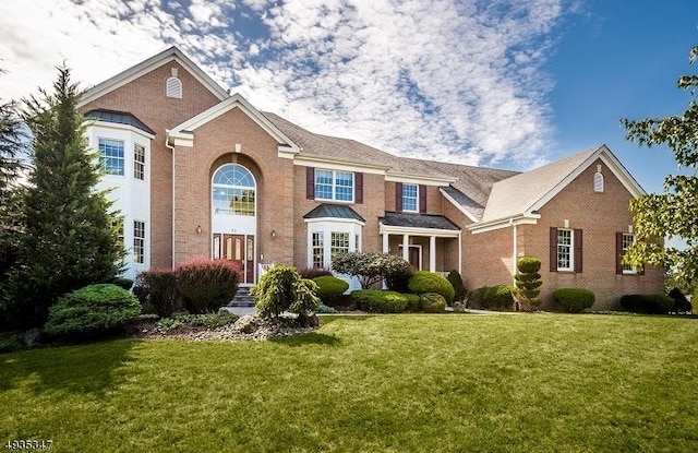 view of front of property featuring brick siding and a front lawn