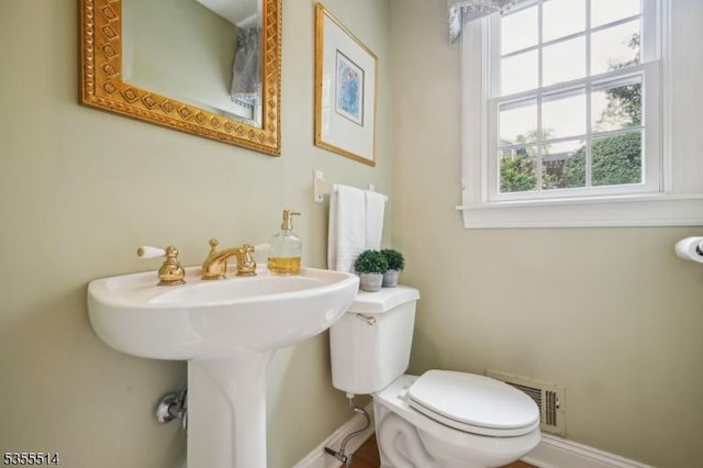 bathroom with baseboards and toilet