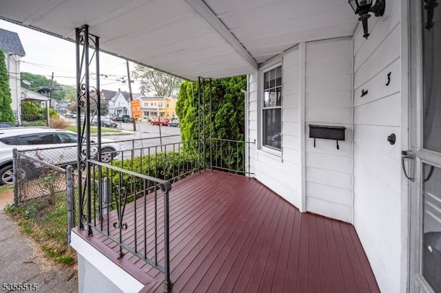 wooden deck with covered porch and a residential view