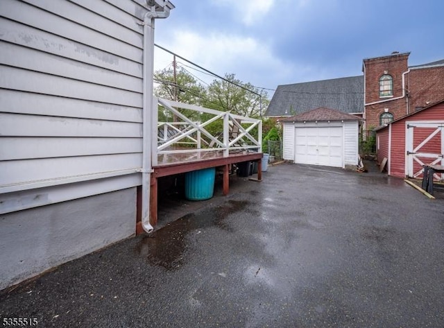 view of property exterior featuring a storage shed, a garage, an outbuilding, and driveway