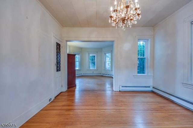 unfurnished dining area with an inviting chandelier, a baseboard radiator, light wood-style flooring, and crown molding