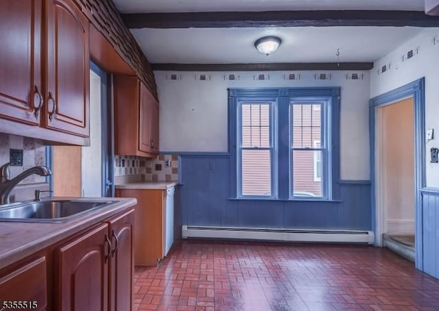 kitchen with backsplash, brick patterned floor, a sink, and a baseboard radiator