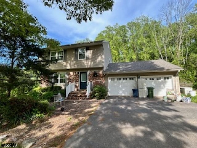 colonial home featuring asphalt driveway and a garage