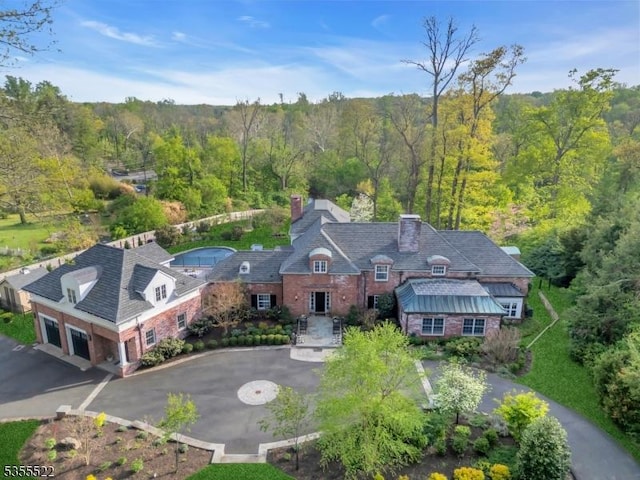 birds eye view of property featuring a forest view