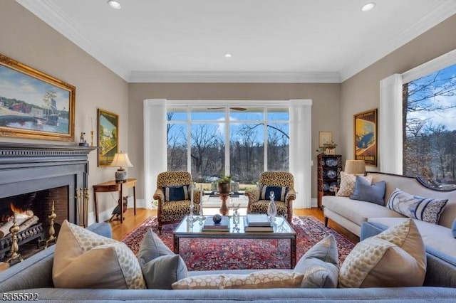 living area featuring recessed lighting, a lit fireplace, ornamental molding, and wood finished floors