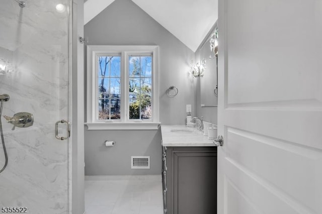 bathroom featuring vanity, a marble finish shower, marble finish floor, vaulted ceiling, and visible vents