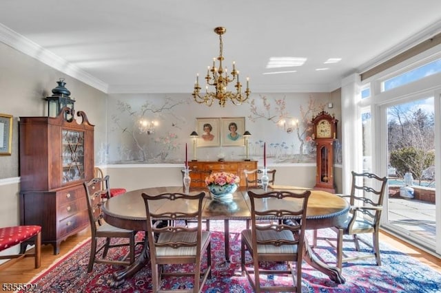 dining area featuring a chandelier, ornamental molding, and wood finished floors