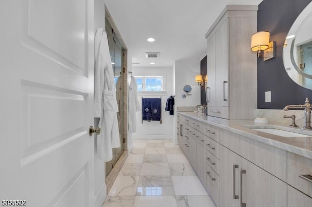 full bathroom featuring visible vents, double vanity, marble finish floor, a shower stall, and a sink