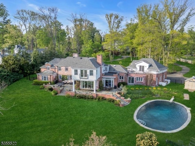 back of house featuring a yard, a chimney, and a patio area