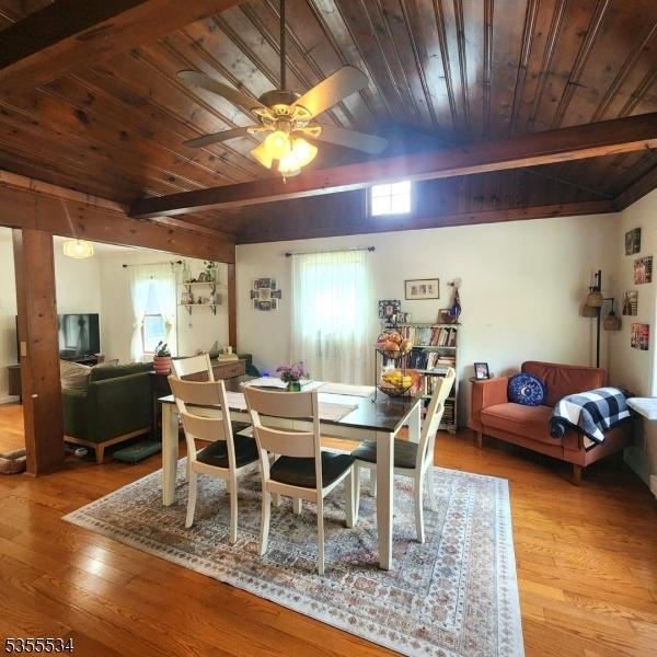 dining area featuring lofted ceiling with beams, ceiling fan, hardwood / wood-style floors, and wooden ceiling