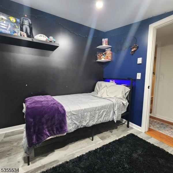 bedroom featuring baseboards and wood finished floors