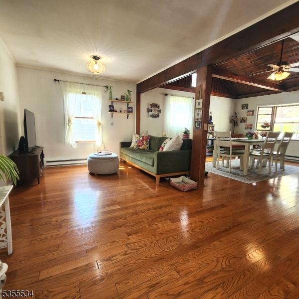 living room featuring a ceiling fan, baseboard heating, and wood finished floors