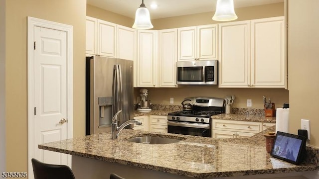7104 Minuteman Ln, Franklin Twp, NJ 08873 - kitchen featuring appliances with stainless steel finishes, a sink, light stone countertops, a kitchen bar, and hanging light fixtures