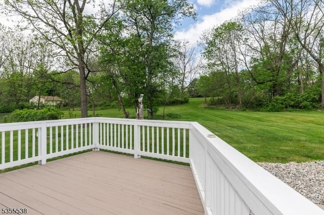 wooden terrace featuring a yard and view of wooded area