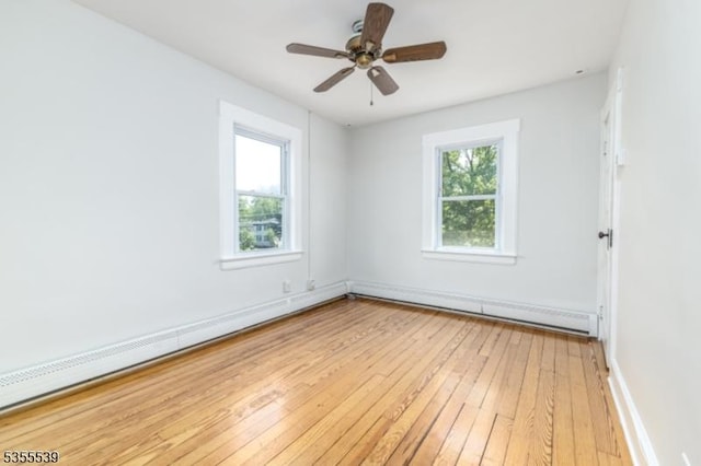 unfurnished room with light wood-type flooring, baseboard heating, baseboards, and a ceiling fan