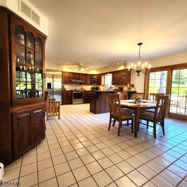 202 Fredon Springdale Rd, Fredon Twp, NJ 07860 - dining area with light tile patterned floors, a notable chandelier, visible vents, and plenty of natural light