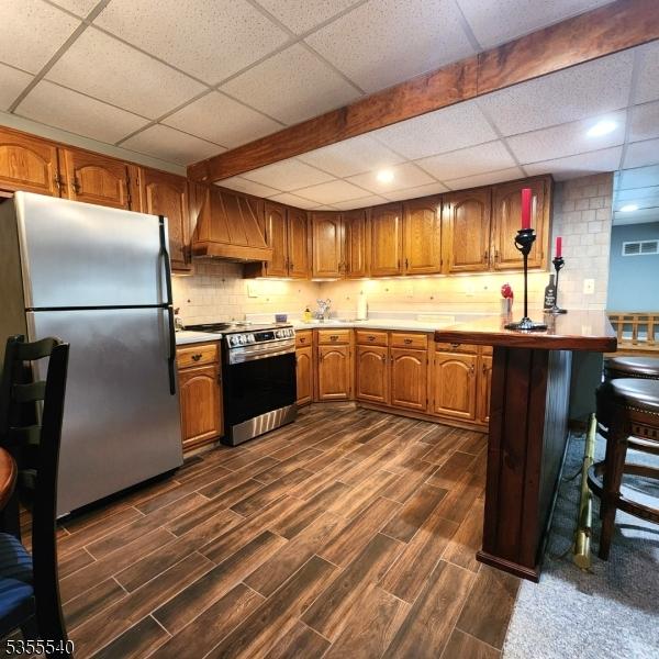 202 Fredon Springdale Rd, Fredon Twp, NJ 07860 - kitchen with brown cabinets, dark wood-style flooring, a drop ceiling, custom range hood, and appliances with stainless steel finishes
