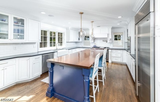 9 Warwick Rd, Chatham Twp, NJ 07928 - kitchen with appliances with stainless steel finishes, dark wood-style flooring, a kitchen bar, white cabinetry, and recessed lighting