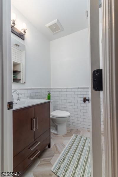 9 Warwick Rd, Chatham Twp, NJ 07928 - bathroom featuring tile walls, vanity, toilet, and wainscoting