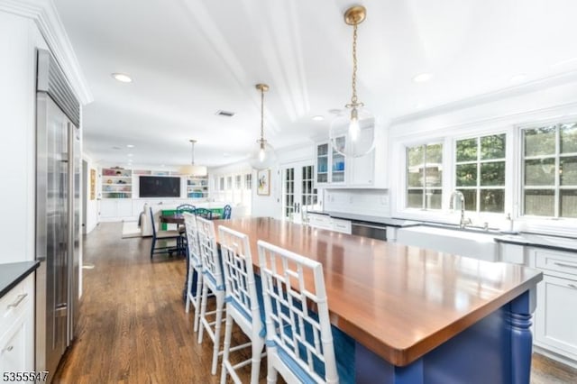 9 Warwick Rd, Chatham Twp, NJ 07928 - kitchen with white cabinetry, a center island, dark wood-type flooring, glass insert cabinets, and recessed lighting