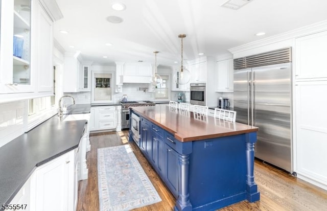 9 Warwick Rd, Chatham Twp, NJ 07928 - kitchen with high end appliances, blue cabinets, white cabinets, a sink, and wood finished floors