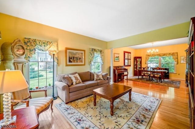 living room featuring a chandelier, plenty of natural light, and light wood-type flooring