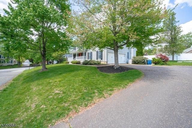view of property hidden behind natural elements featuring driveway
