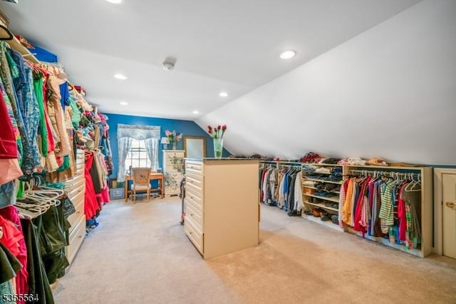 walk in closet featuring light colored carpet and vaulted ceiling