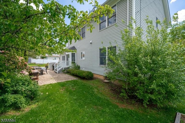 rear view of property featuring a patio and a lawn