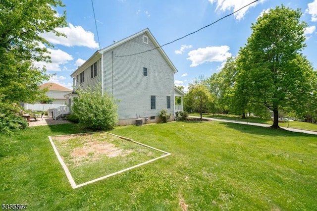 back of house with a lawn and central AC