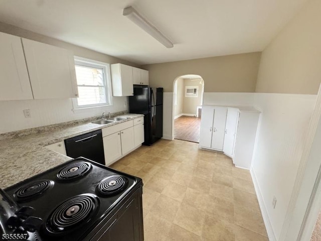 633 Warren St, Phillipsburg Town, NJ 08865 - kitchen with light countertops, arched walkways, white cabinets, a sink, and black appliances