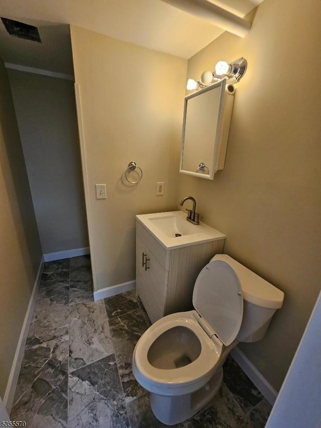 bathroom with marble look tile flooring, baseboards, toilet, and vanity
