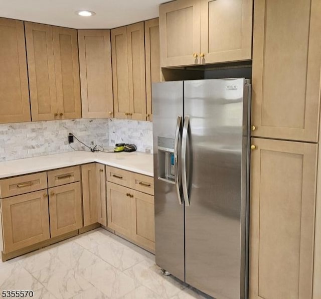 kitchen with stainless steel fridge with ice dispenser, light marble finish flooring, light countertops, recessed lighting, and backsplash
