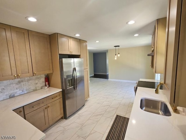 kitchen with stainless steel refrigerator with ice dispenser, light marble finish flooring, recessed lighting, a sink, and pendant lighting