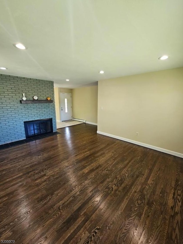 unfurnished living room featuring wood finished floors, baseboards, a fireplace, and recessed lighting