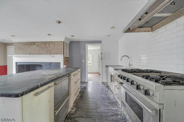 29 S Valley Rd, West Orange Twp, NJ 07052 - kitchen with under cabinet range hood, high end stainless steel range, backsplash, a sink, and a fireplace