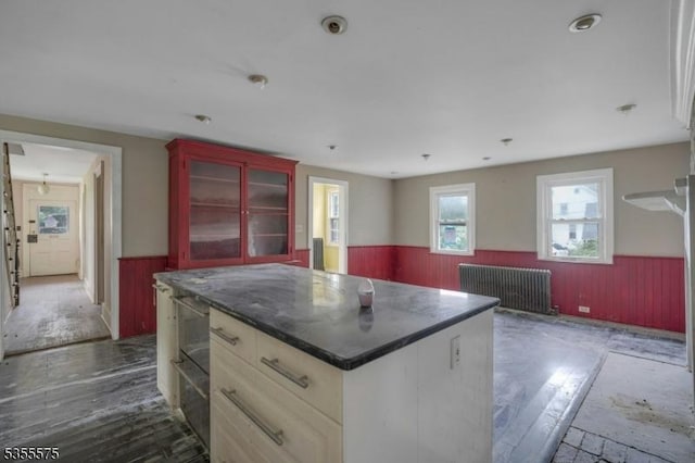 29 S Valley Rd, West Orange Twp, NJ 07052 - kitchen featuring a wainscoted wall, wood walls, wood finished floors, a center island, and radiator heating unit