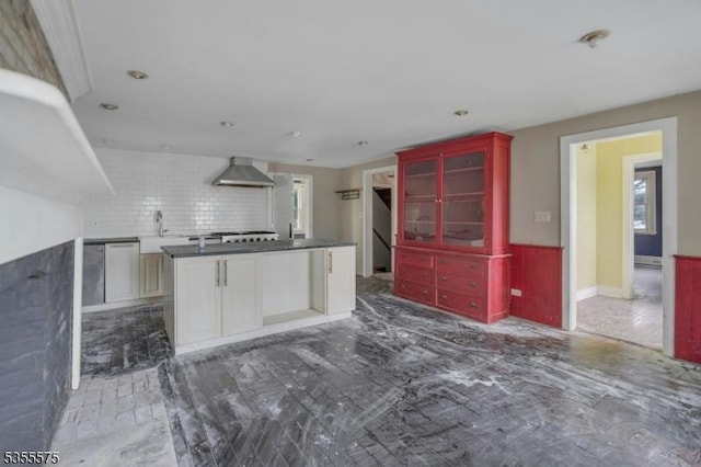 29 S Valley Rd, West Orange Twp, NJ 07052 - kitchen featuring dark countertops, a sink, wall chimney range hood, wainscoting, and a kitchen island
