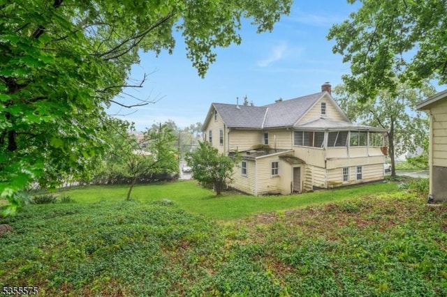29 S Valley Rd, West Orange Twp, NJ 07052 - back of house featuring a chimney, a sunroom, and a yard