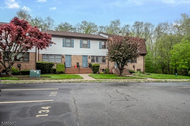 view of front of property featuring uncovered parking and brick siding