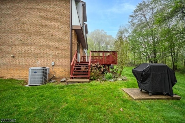view of grassy yard featuring central AC, a deck, and stairs