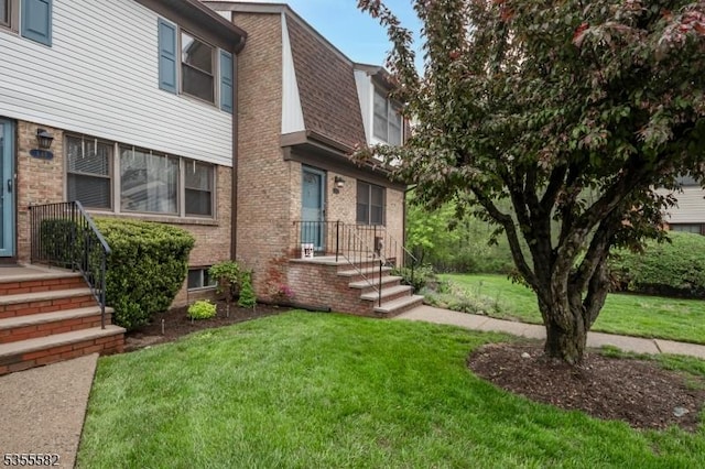 view of front of house with a front yard and brick siding