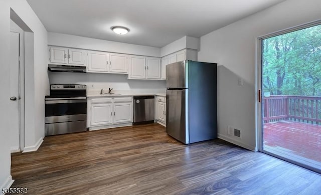 kitchen with stainless steel appliances, under cabinet range hood, light countertops, and white cabinets